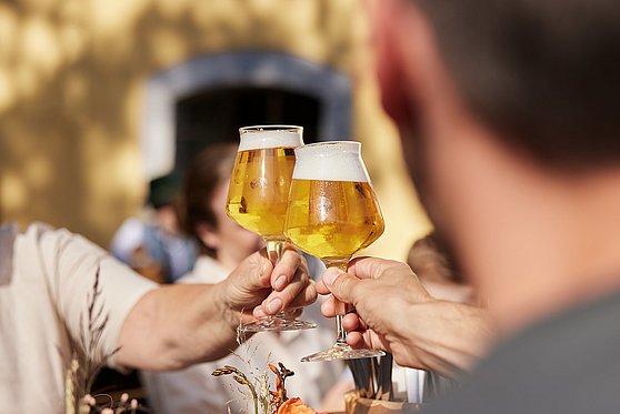 Foto Oberösterreich Tourismus/SINNVIERTEL Tourismus/Stefan Mayerhofer: Anstoßen mit frisch gezapftem Bier im Gastgarten beim Rieder Wirt.